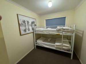 Piccola camera con letto a castello e finestra. di Grafton Workers Accomodation a Grafton