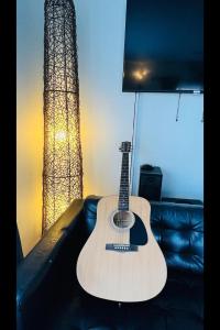 une guitare assise sur un canapé avec une lampe dans l'établissement Dream Guesthouse, à Vík