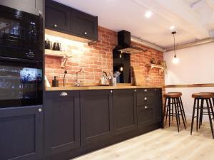 uma cozinha com armários pretos e uma parede de tijolos em Newly Renovated Stunning Warehouse Apartment em Bournemouth