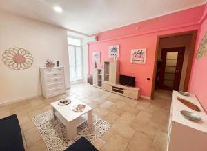 uma sala de estar com paredes cor-de-rosa e uma mesa em Novità in centro a Cagliari em Cagliari