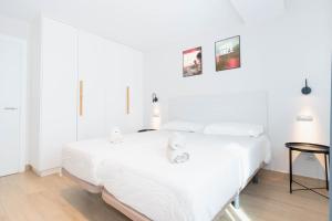 - une chambre blanche avec un lit et une table dans l'établissement Sholeo Lodges La Cícer Flats, à Las Palmas de Gran Canaria