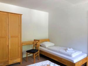 a small bedroom with a bed and a chair at Ferienhaus Schwanennest in Zell an der Mosel