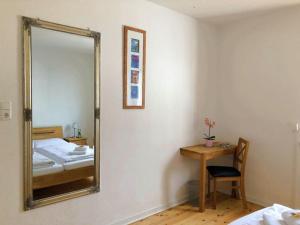 a mirror in a room with a bed and a table at Ferienhaus Schwanennest in Zell an der Mosel