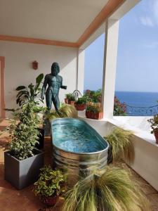 uma estátua de um homem numa sala com plantas em Villa Santa Chiara Positano Suites em Positano