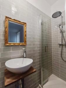 bagno con lavandino e doccia con specchio di Chambres cosy au coeur du village a Chaumont-en-Vexin