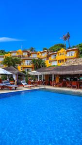 una piscina con sillas y sombrillas en un complejo en Bahiamarela Boutique Hotel & SPA, en Búzios