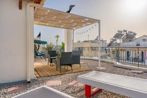 patio ze stołem i krzesłami na tarasie w obiekcie Rooftop 11 w Kalamácie