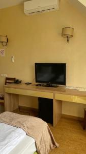 a room with a desk with a flat screen tv at Pivdenna Brama in Khmelʼnytsʼkyy