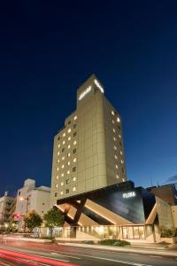 Un grand bâtiment avec des lumières au-dessus dans l'établissement Hotel Flora Funabashi, à Funabashi