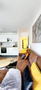 un soggiorno con divano marrone e cuscini gialli di New & serene 1-bedroom apart near #LaDéfenseParis #Parking&Fibre a Suresnes