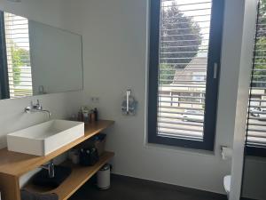 a bathroom with a white sink and a mirror at Zum EM Stadion zu Fuß - Luxus im Grünen in Cologne