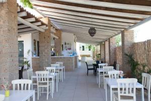 ein Restaurant mit weißen Tischen und weißen Stühlen in der Unterkunft HOTEL SoleMare Gallipoli in Gallipoli