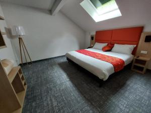 a bedroom with a large bed with a red headboard at Hôtel de L'ile in Custines