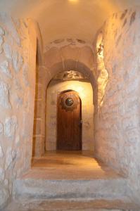 a hallway with a wooden door in a stone wall at La Maison d'Anne in Paris