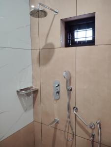 un bagno con doccia e porta in vetro di MATHER RAJAGIRI FURNISHED APARTMENTS ad Alwaye