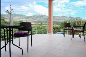 een balkon met tafels en stoelen en uitzicht op de bergen bij Apartment Trebinje in Trebinje