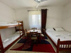 Zimmer mit 2 Etagenbetten und einem Tisch in der Unterkunft Xhou's Home in Shkodra