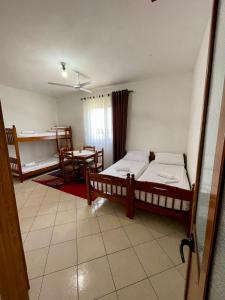 Zimmer mit 2 Betten und einem Tisch in der Unterkunft Xhou's Home in Shkodra