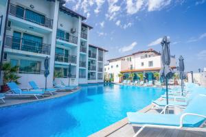 - une piscine avec des chaises et des parasols à côté des bâtiments dans l'établissement Royal Calisto Hotel, à Sozopol