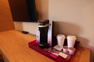 eine Kaffeemaschine und zwei Tassen auf dem Tisch in der Unterkunft Le Fabreville Motel & Suites in Laval