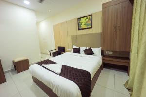 a bedroom with a large bed in a room at JKInn in Vellore