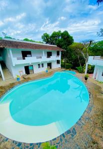 une grande piscine en face d'une maison dans l'établissement Hotel Océan Beach Sakatia, à Nosy Be