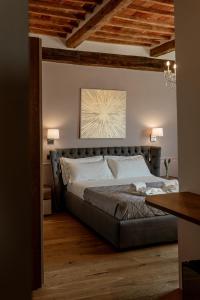 a bedroom with a bed in a room with wooden ceilings at Neoclassico by Tiziana Monaldi in Pitigliano