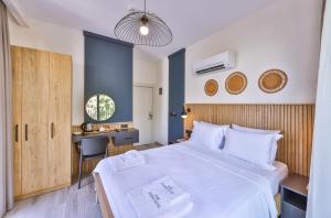 - une chambre avec un grand lit blanc et un bureau dans l'établissement Kas Athena Hotel, à Kaş