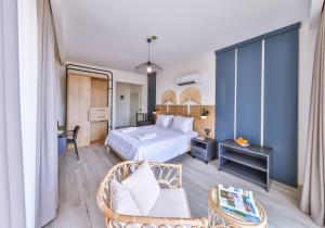 une chambre d'hôtel avec un lit et une chaise dans l'établissement Kas Athena Hotel, à Kaş