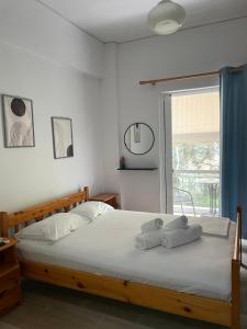 1 dormitorio con 1 cama con 2 toallas en Sunshine Apartments and Rooms, en Nikiana