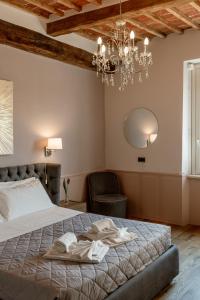 a bedroom with a bed and a chandelier at Neoclassico by Tiziana Monaldi in Pitigliano