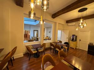 a dining room with tables and chairs and a window at Hotel Le Jacquemart in Dijon