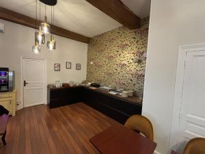 a dining room with a table and a wall with floral wallpaper at Hotel Le Jacquemart in Dijon