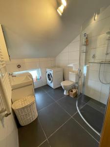 a bathroom with a shower and a toilet and a sink at JZ apartamentai in Kelmė