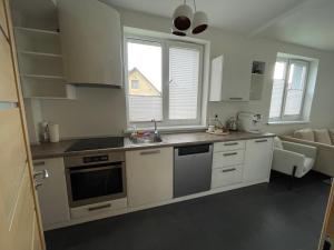 a kitchen with white cabinets and a sink and a window at JZ apartamentai in Kelmė