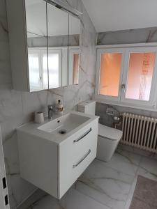 bagno bianco con lavandino e servizi igienici di Mon Amour Apartment a Interlaken