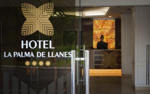 un hombre parado frente a un hotel con un portátil en Hotel La Palma de Llanes, en Llanes