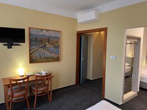 um quarto com uma mesa e cadeiras e uma televisão em Hotel Praha Liberec em Liberec