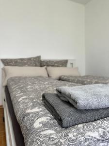 a bed with a blanket and pillows on it at Double Bed Apartment - Near Marienplatz in Stuttgart