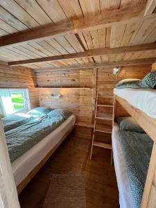 een kamer met 2 bedden in een houten hut bij Hytte C in Gråsten