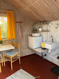 a kitchen with a sink and a table and a counter at Hytte A in Gråsten