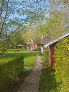 a brick walkway leading to a house in a yard at Hytte A in Gråsten