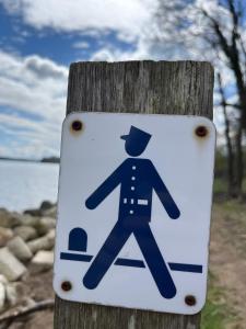 a sign on a wooden pole with a pedestrian at Hytte A in Gråsten