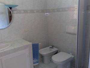 een witte badkamer met een toilet en een wastafel bij Casa Sirina in Terracina