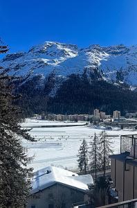 vistas a un campo cubierto de nieve con una montaña en Sankt Moritz Suite, en St. Moritz