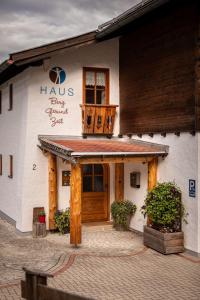 un edificio con porta in legno e balcone di Haus BergGesundZeit Doppelzimmer Kärlingerhaus a Schönau am Königssee