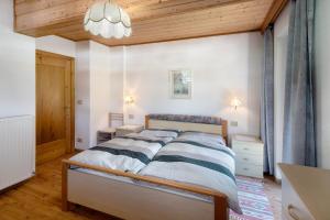 una camera con letto e soffitto in legno di Appartamento Cesa Portados Gabi 2 a Livinallongo del Col di Lana