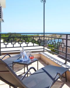 a balcony with two chairs and a table on a roof at Niko's Sea View Apartments Deluxe in Nesebar