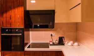 a kitchen with a black microwave and a stove at City Park Hotel Apartments in Muscat