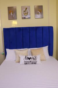 un letto con testiera blu e cuscini di CK Homes a Voi